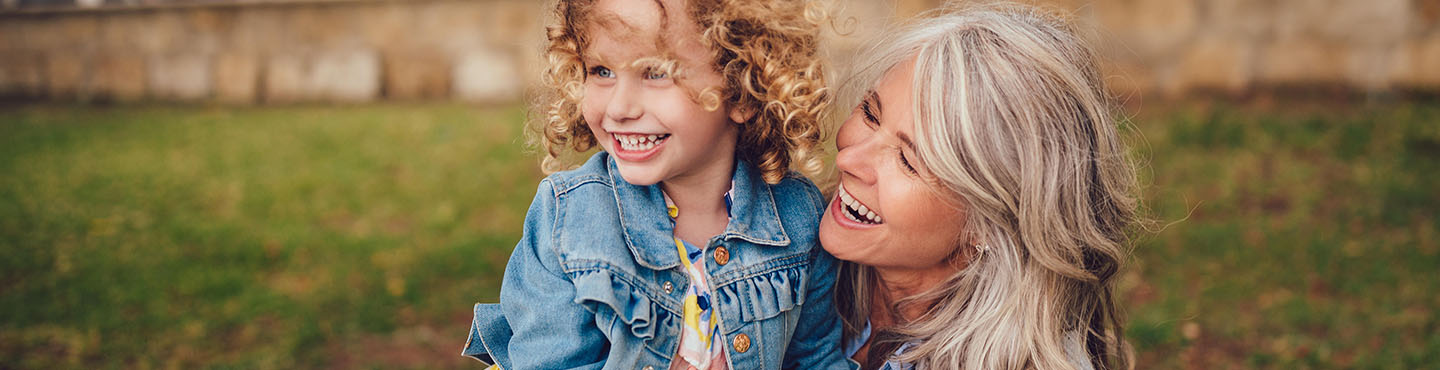 Grandma and granddaughter outside smiling together