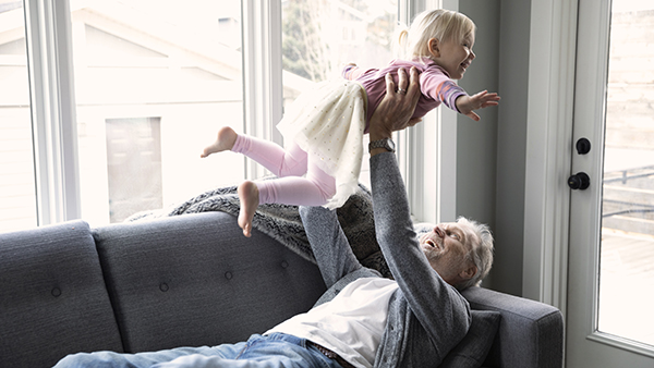 Grandfather playing with Granddaughter in living room